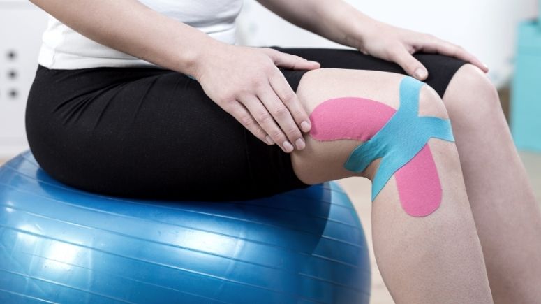 physical therapist using kinesiology tape