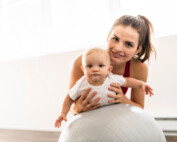 young mother with baby on an exercise ball