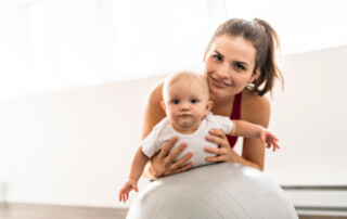 young mother with baby on an exercise ball