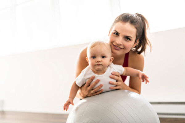 young mother with baby on an exercise ball