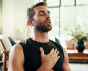 man with hand on heart taking a breath