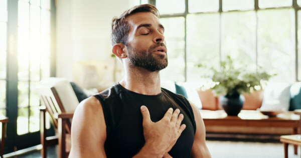 man with hand on heart taking a breath